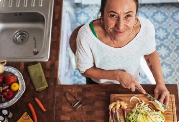 Uma jovem senhora cozinhando com uma expressão de satisfação