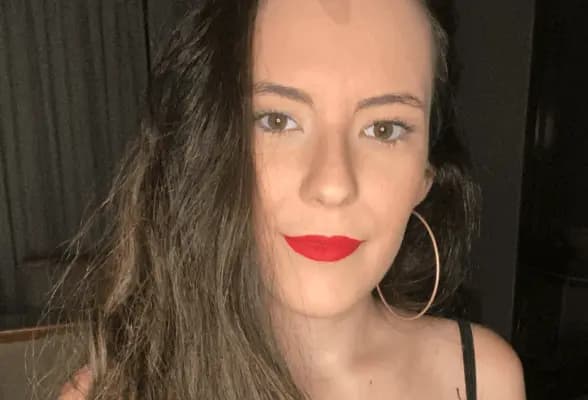 Uma mulher de cabelos longos escuros com uma expressão de seriendade